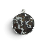 Rare Earth Gallery circular Sericho pallasite meteorite pendant with a faceted sapphire in 925 sterling silver