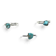 Rare Earth Gallery turquoise nugget dot rings with round silver bands arranged on a white background