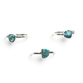 Rare Earth Gallery turquoise nugget dot rings with round silver bands arranged on a white background