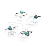 Rare Earth Gallery turquoise nugget rings with round silver bands displayed on clear stands