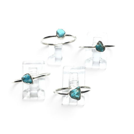 Rare Earth Gallery turquoise nugget rings with round silver bands displayed on clear stands